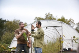 Two guys standing in front of a greenhouse